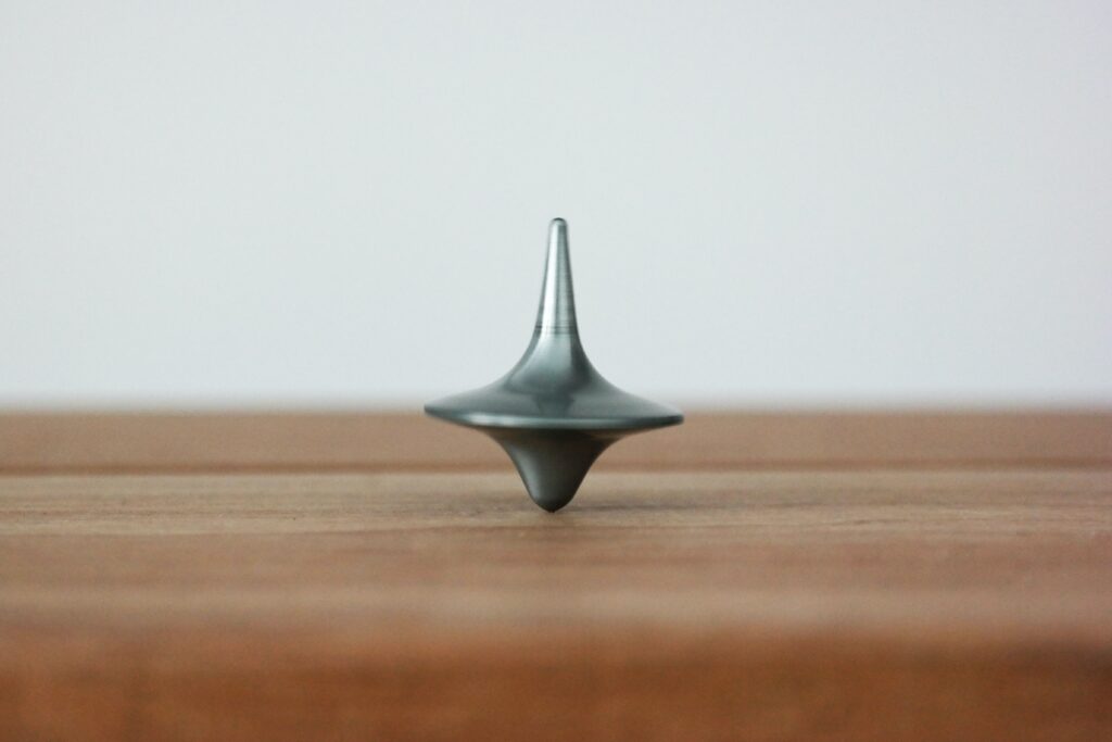 Metal spinning top on a wooden desk
