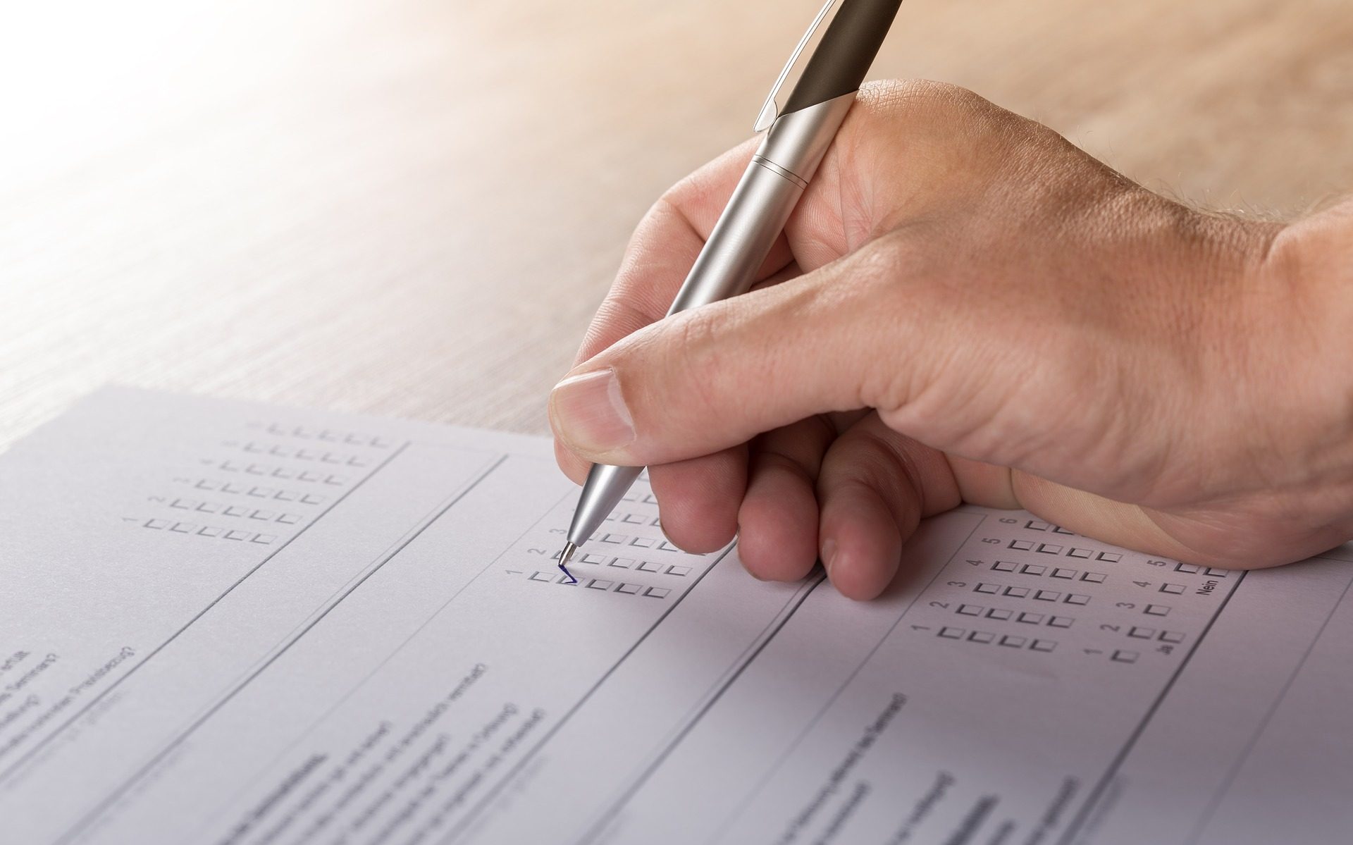 Hand with a pen filling a form